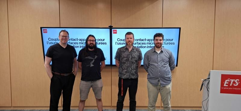 Group photograph at ÉTS beside screens presenting research on surface wear